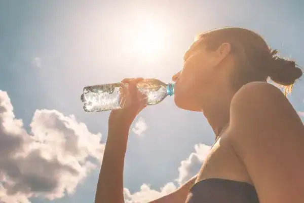 Hydration: The Secret Ingredient for a Toned Stomach and Enhanced Fitness 3 Image of woman drinking water to hydrate Lewes after run.