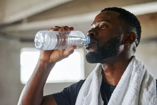 Hydration: The Secret Ingredient for a Toned Stomach and Enhanced Fitness 1 Image of man drinking water to improve hydration Lewes after work out.